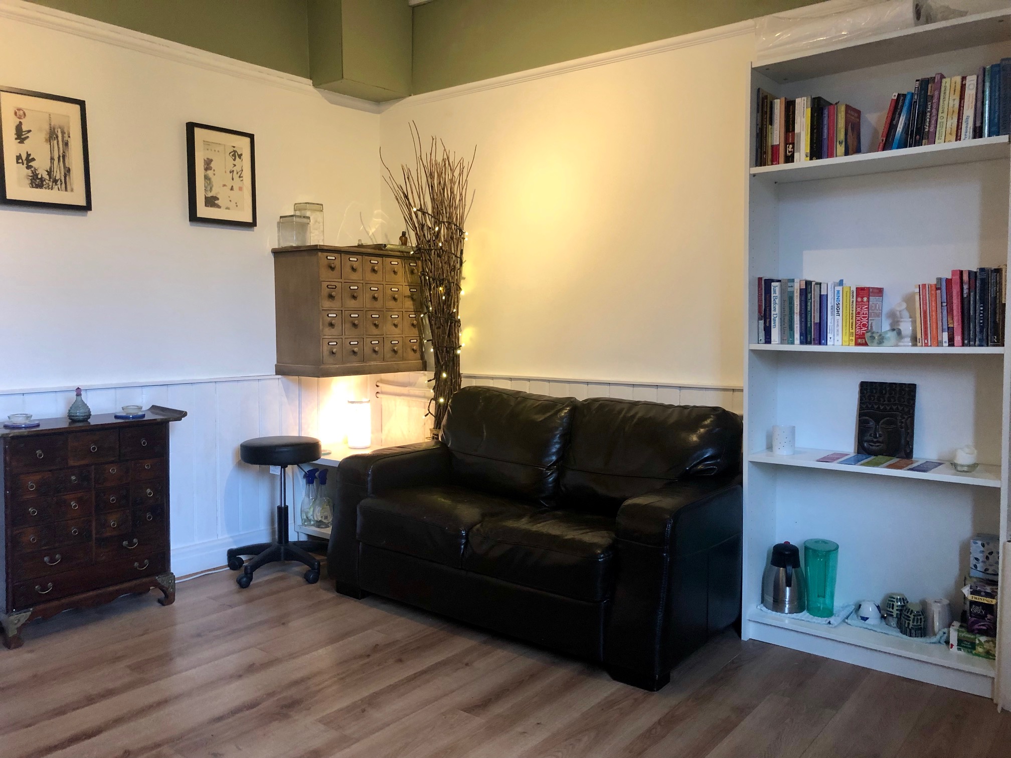 The other side of the room showing a leather sofa and bookcases